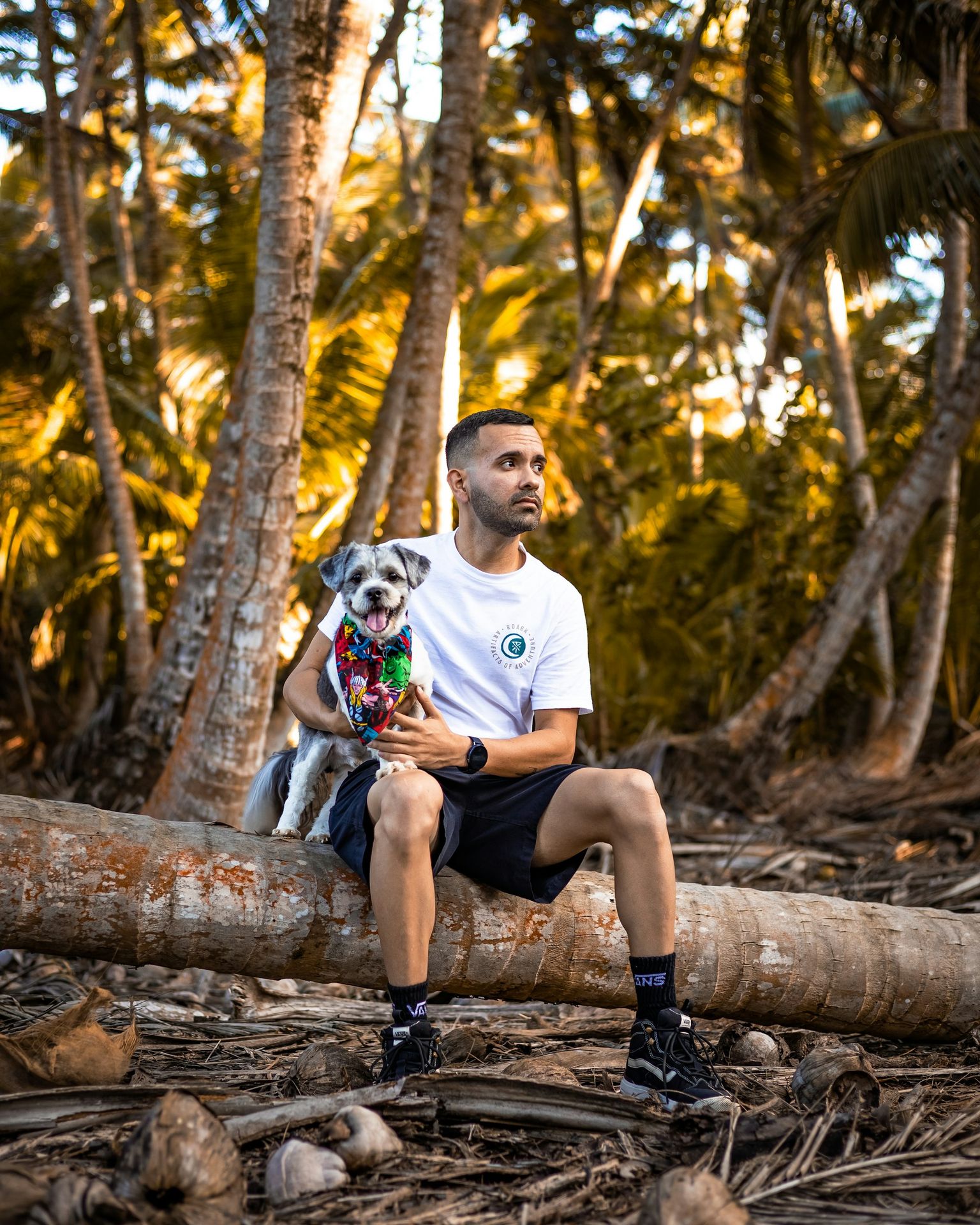 man in blue crew neck t-shirt and brown shorts sitting on brown tree log during